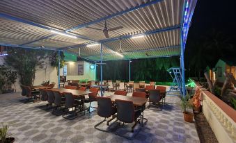 an outdoor dining area with multiple tables and chairs arranged for a group of people to enjoy a meal together at Hotel Palms