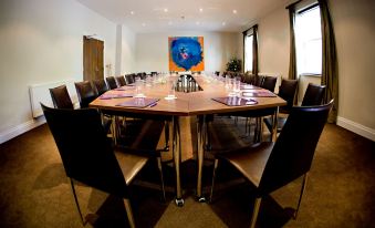 a conference room with a wooden table , chairs , and a painting of a blue flower on the wall at Best Western Plus Aston Hall Hotel