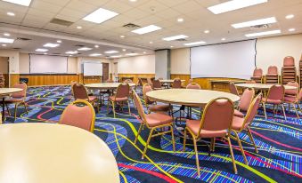 a large conference room with multiple round tables and chairs , set up for an event at Magnuson Hotel Wildwood Inn Crawfordville