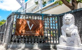 a white lion statue is standing next to a metal gate in front of a building at Ocean V Hotel