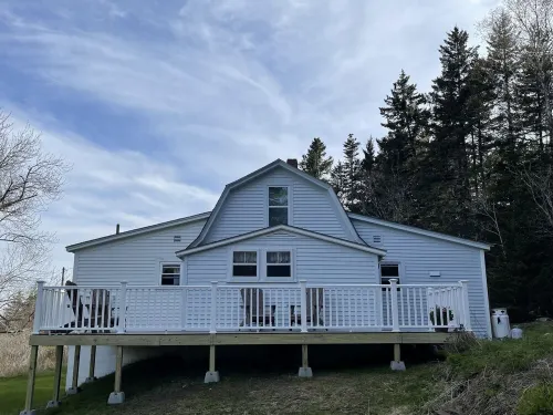 Rustic vintage cottage in Duck Cove with limited ocean view.