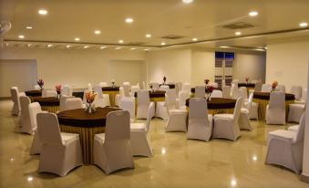 a large banquet hall with multiple round tables covered in white tablecloths , set for a formal event at Hotel Bella Vista