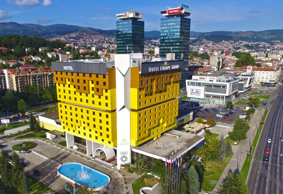 a large hotel building with two towers and a swimming pool in front of it at Hotel Holiday