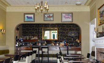 a restaurant with a bar and dining area , featuring a variety of chairs and tables at Hundith Hill Hotel