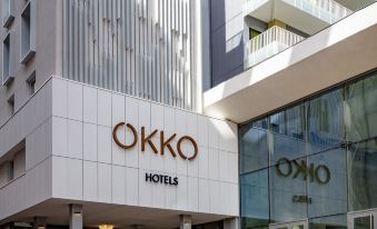 "a modern building with the word "" okko "" prominently displayed on the front , and a large glass window at the entrance" at Okko Hotels Toulon Centre