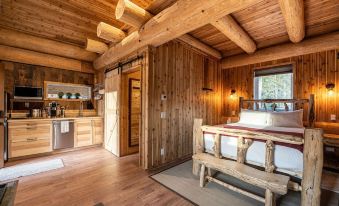 a cozy bedroom with wooden walls and a bed , surrounded by a kitchen area with various appliances at Boulder Mountain Resort