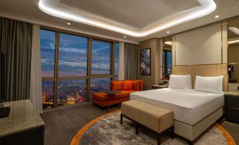 a modern hotel room with a large window overlooking the city , featuring a bed , couch , and seating area at Hilton Mall of Istanbul