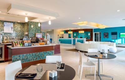 a modern , well - decorated restaurant with white and blue furniture , including tables , chairs , and a bar at Wyndham Reef Resort Grand Cayman