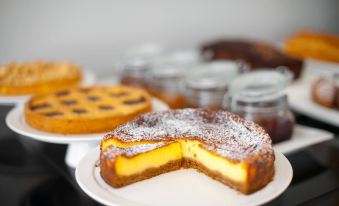 a dining table with a variety of cakes and pastries on plates , including cheesecakes , pies , and tarts at Palazzo Castri 1874 Hotel & Spa