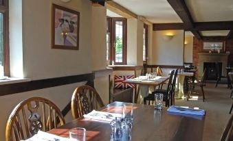 a dining room with wooden tables and chairs arranged for a group of people to enjoy a meal together at Derby Inn