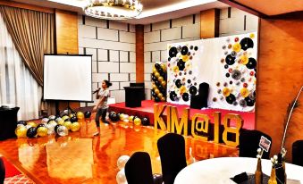 a room with a stage and table set up for an event , featuring balloons and a large number at StarLodge
