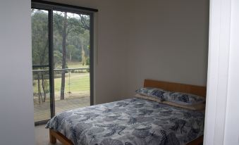 a bedroom with a bed and floral bedding , next to a sliding glass door that leads to a balcony at Craggy Peaks