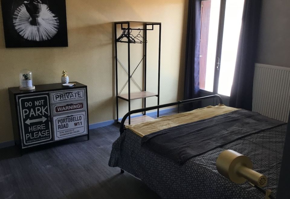 a modern bedroom with wooden flooring , black furniture , and a black dog crate on the floor at Marina