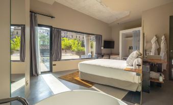 a modern bedroom with a large bed , a bathtub , and a view of an outdoor patio at Hotel Viura