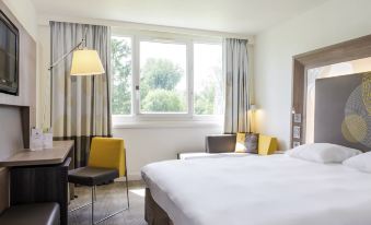 a hotel room with two beds , one on the left and one on the right side of the room at Novotel le Mans