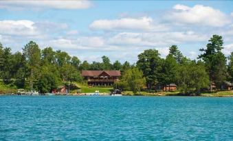 a large body of water with a wooden house on an island in the middle at Sugar Lake Lodge