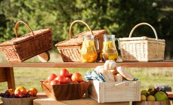 a wooden table with a variety of food and drinks , including apples , oranges , and bread at Niddo Suesca
