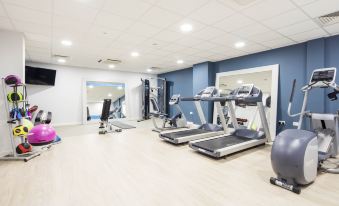 a well - equipped gym with various exercise equipment , such as treadmills , weight machines , and stationary bikes at Hampton by Hilton Humberside Airport