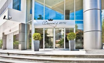 a modern hotel entrance with glass doors , a staircase , and potted plants , offering a view of the ocean at Queen's Hotel - Zebra Centre