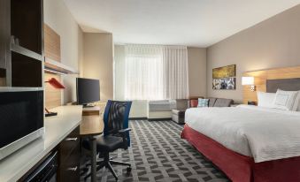 a hotel room with a king - sized bed , a desk , a chair , and a tv . the room is clean and well - organized at TownePlace Suites Memphis Southaven