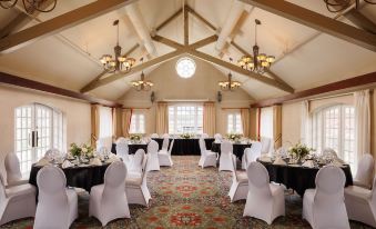 a large room with tables set up for a formal event , surrounded by chairs and chandeliers at St. Eugene Golf Resort & Casino