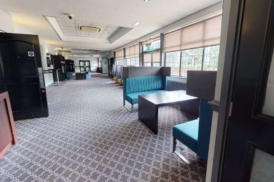 a large , empty room with multiple chairs and couches arranged in an orderly fashion , creating a comfortable seating area at Village Hotel Liverpool