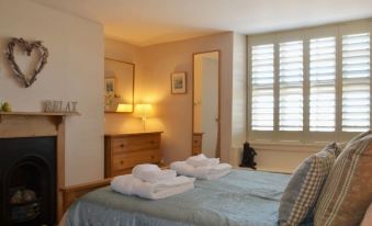 a well - lit bedroom with two beds , one on the left side of the room and the other on the right side at Lakeside