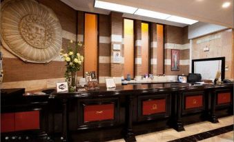 a large , elegant hotel lobby with a black and gold reception desk in the center at Nova Roma