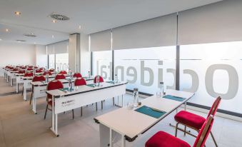 a conference room with white tables and red chairs , set up for a meeting or event at Occidental Fuengirola