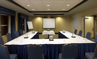 a conference room set up for a meeting with multiple chairs arranged in a semicircle around a long table at Homewood Suites by Hilton Dover - Rockaway