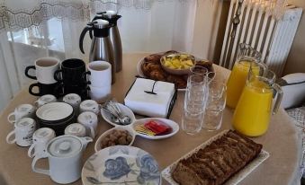 a table is set with a variety of breakfast items , including coffee , juice , and pastries at The Corner Properties