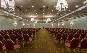 a large conference room with rows of chairs arranged in a semicircle , ready for an event at Falcon Hotel