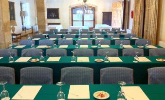 a large conference room with multiple rows of tables and chairs , all facing the same direction at Parador de Zamora