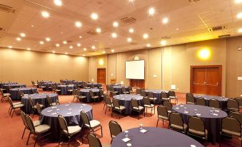 a large conference room with multiple round tables and chairs arranged for a meeting or event at Búzios Beach Resort Luxo II