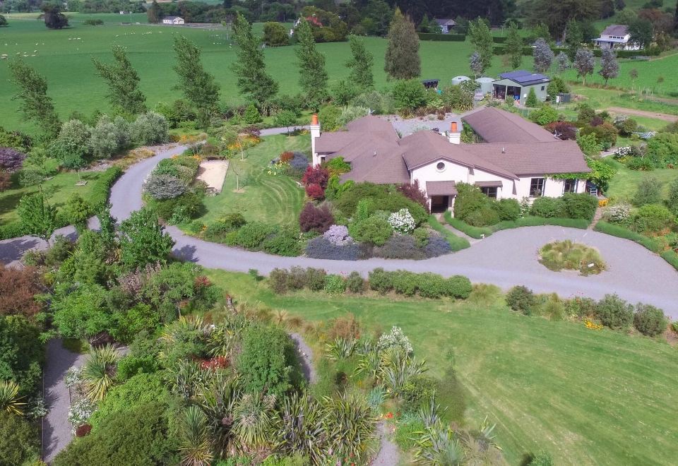 an aerial view of a house surrounded by greenery , including trees , bushes , and a dirt road at The Summit Lodge