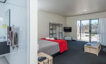 a modern hotel room with a large bed , a tv , and a bathroom with a shower at Greenwood Park
