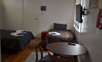 a small room with three beds , two of which are twin beds and one is a bunk bed at Wondai Accommodation Units and Villas