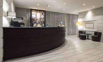 a modern bar with black cabinets and a curved counter , featuring a wine rack behind it at Best Western CTC Hotel Verona