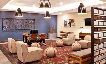 a modern lounge area with a red and white striped rug , several chairs , and a television at Four Points by Sheraton Saginaw