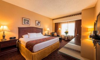 a large bed with a brown headboard is in the middle of a hotel room at Cherokee Casino West Siloam Springs Resort