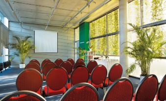 a conference room with rows of chairs arranged in a semicircle , and a projector on the wall at Tropical Islands