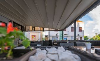 an outdoor dining area with a wooden table , chairs , and an umbrella , providing shade and protection from the elements at Hotel Park