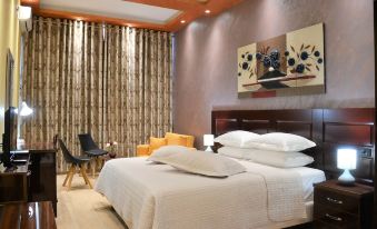 a large bed with white linens is in a room with wooden floors and curtains at Comfort Hotel