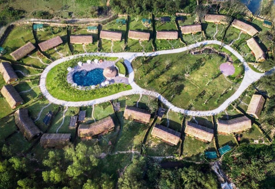 a bird 's eye view of a large resort with multiple buildings and a pool surrounded by greenery at Alba Wellness Resort by Fusion
