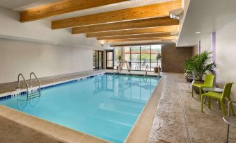 an indoor swimming pool surrounded by a lounge area , with several chairs placed around it at Home2 Suites by Hilton Downingtown Exton Route 30