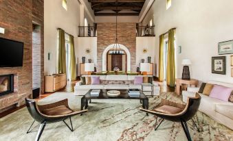 a modern living room with two large couches , a coffee table , and multiple chairs arranged around it at The Westin Resort, Costa Navarino