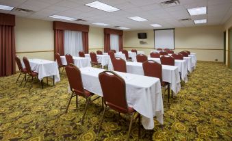 a large conference room with multiple tables and chairs arranged for a meeting or event at Country Inn & Suites by Radisson, Watertown, SD