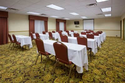 a conference room set up for a meeting , with tables and chairs arranged in rows at Country Inn & Suites by Radisson, Watertown, SD