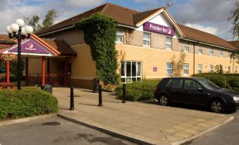 "a car is parked in front of a purple and yellow hotel , which has a sign that reads "" premier hotel ""." at Premier Inn Pontefract North