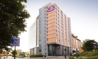 a large building with a purple sign on top and people walking in front of it at Premier Inn Sheffield City Centre (St Mary's Gate)